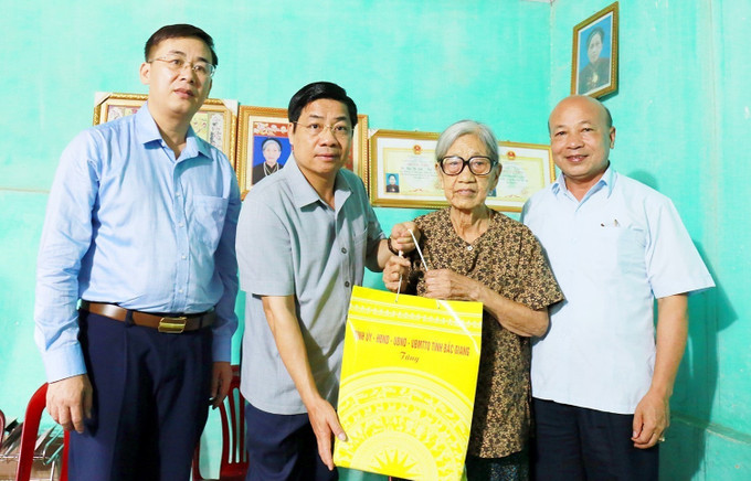 Bí thư Tỉnh ủy Bắc Giang Dương Văn Thái tặng quà bà Ong Thị Sinh, vợ liệt sĩ Ong Khắc Phi ở thôn Bình Voi, xã Cảnh Thụy, huyện Yên Dũng. Ảnh: Đồng Thúy - TTXVN Nhiều hoạt động tri ân người có công tại Bắc Giang ảnh 1