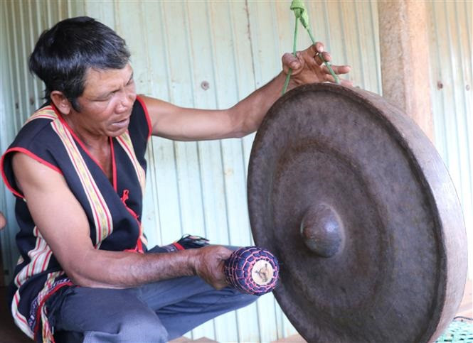 Nghệ nhân làng Mrông Yố 1, xã Ia Ka, huyện Chư Păh (Gia Lai) chỉnh chiêng. Ảnh: Hồng Điệp - TTXVN Lưu giữ âm thanh cồng chiêng Tây Nguyên ảnh 2