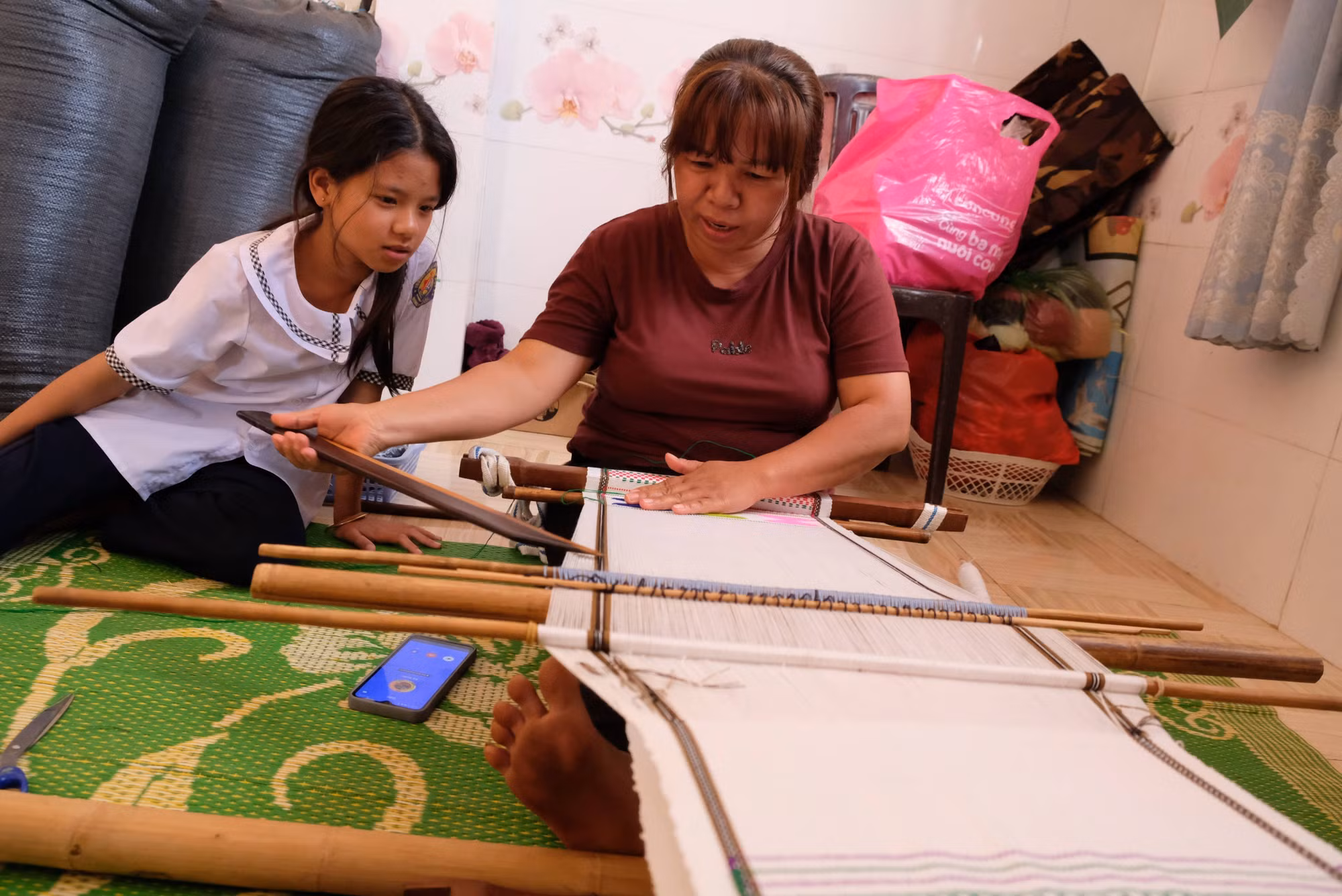 Bà Ka Phép (47 tuổi) truyền dạy cho con gái các kỹ thuật cơ bản của nghề dệt thổ cẩm nhằm giữ gìn nghề truyền thống của dân tộc.