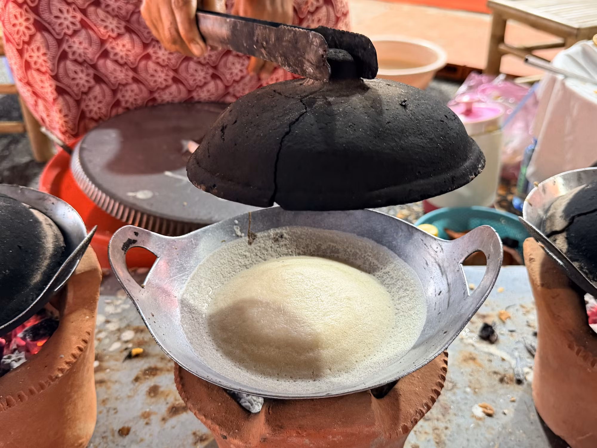 Bánh được đổ vào chảo nhỏ đặt trên bếp đất nung.