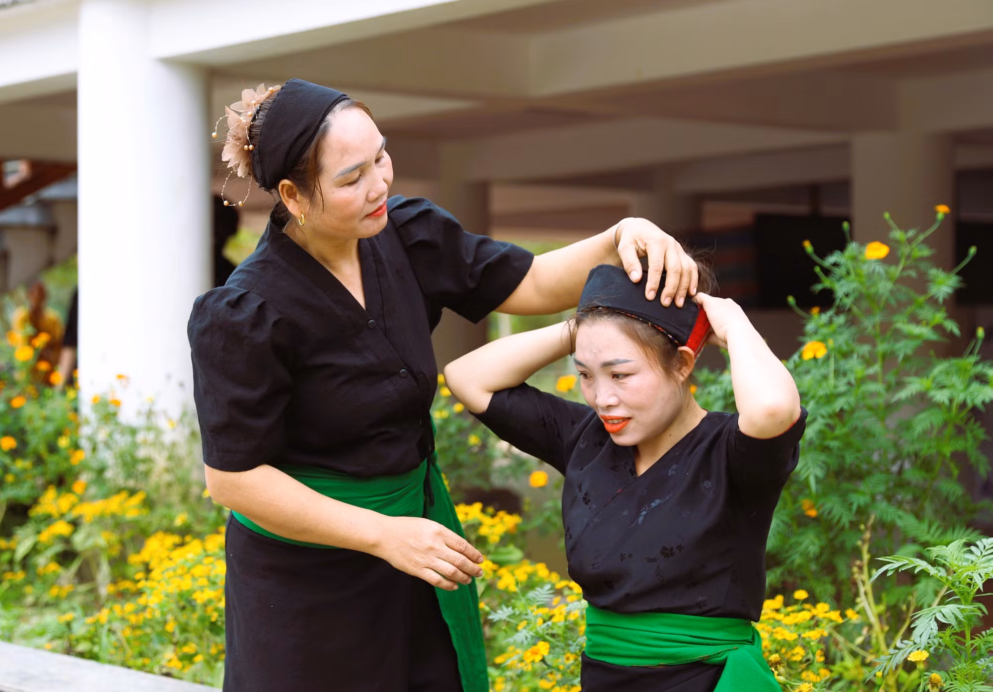 Chị em phụ nữ dân tộc Ơ Đu ở bản tái định cư Văng Môn (xã Nga My, Nghệ An) giúp nhau mặc trang phục truyền thống để cùng bà con dân bản đi dự lễ tiếng đón tiếng sấm đầu năm.