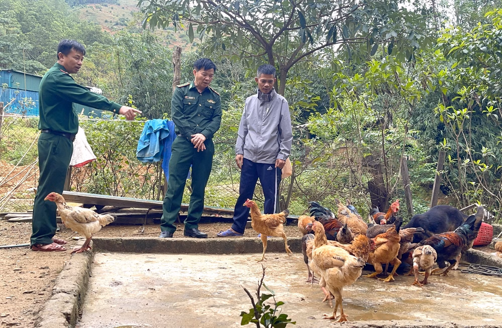 Các cán bộ, chiến sĩ Đồn Biên phòng Cửa khẩu Quốc tế Cha Lo hướng dẫn kĩ thuật chăn nuôi cho người dân. Ảnh: Thanh Thuỷ/TTXVN