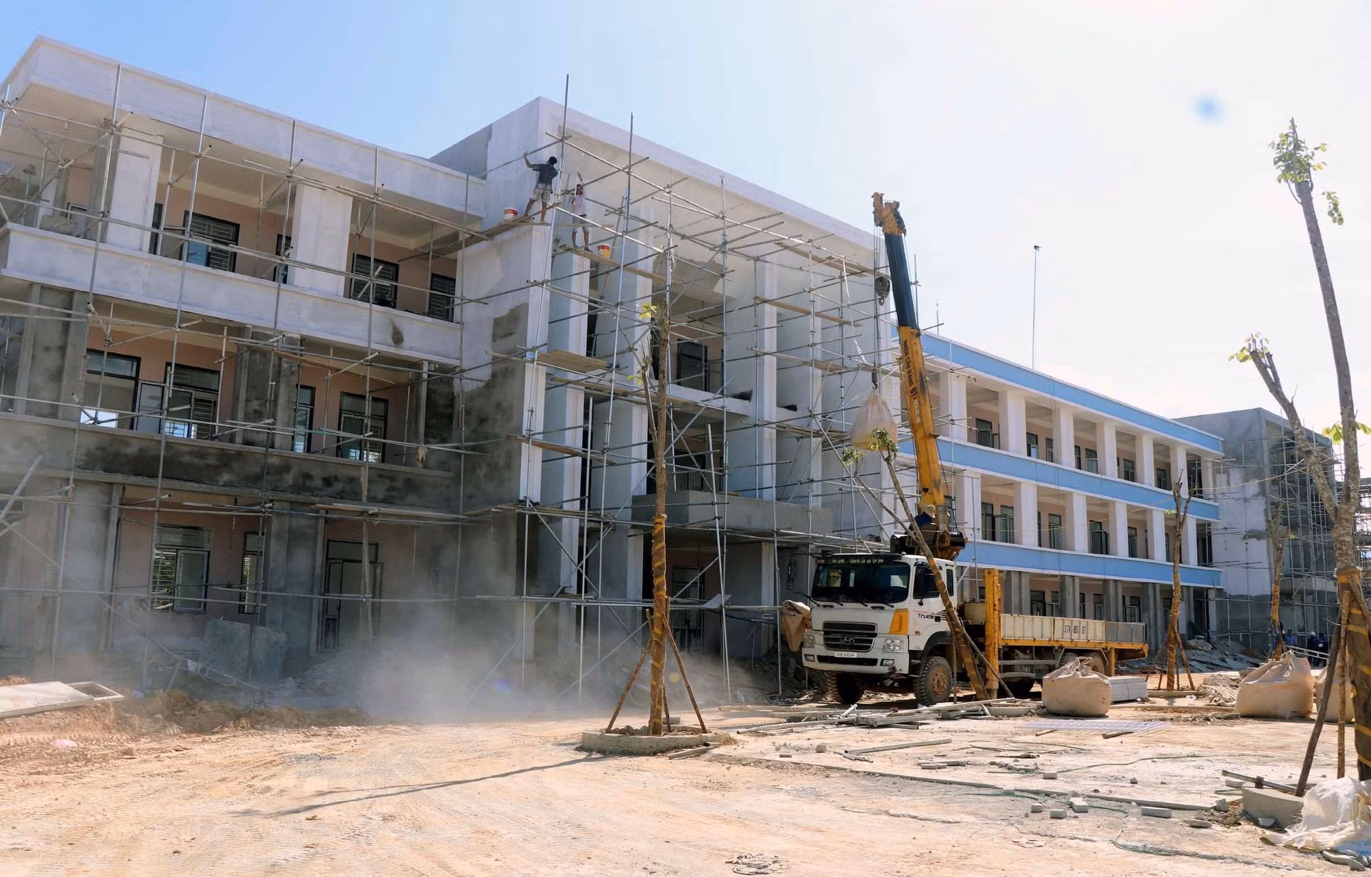 Công nhân đang hoàn thiện khối nhà THCS của trường liên cấp xã Hương Khê.