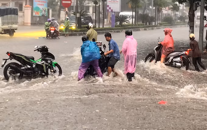 Người tham gia giao thông bị dòng nước chảy xiết xô ngã tại nút giao Bà Triệu - Phan Đình Phùng (đường Hồ Chí Minh đoạn qua phường Kon Tum) trong cơn mưa chiều 10/8/2025.