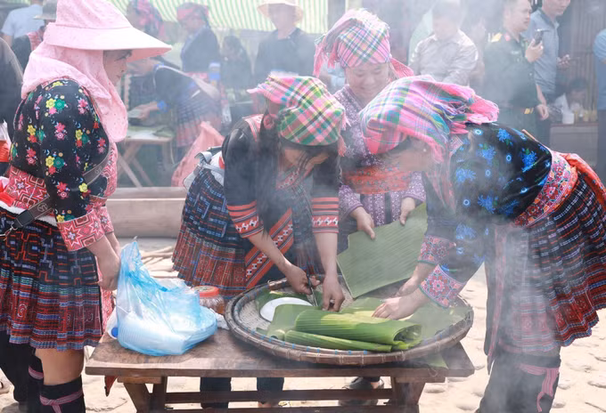 Mỗi người một việc, các thành viên nữ trong đội cắt sẵn lá để đựng bánh giầy sau khi giã xong.