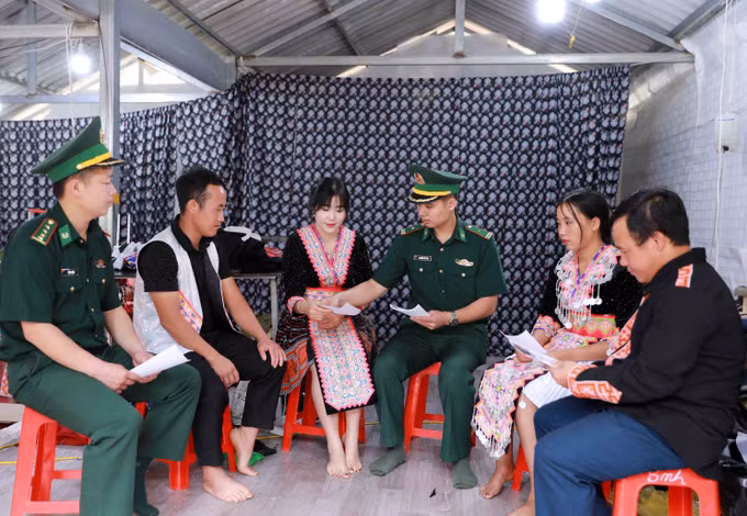Cán bộ Đồn Biên phòng Sin Suối Hồ phát tờ rơi, hướng dẫn người dân tích cực tố giác tội phạm qua hòm thư tại chợ. Ảnh: Quý Trung/TTXVN