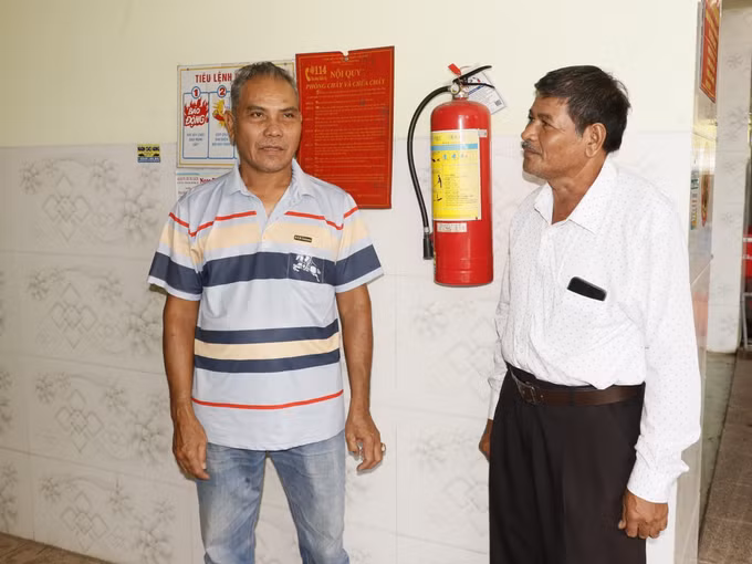 Ông Thạch Bình (phải) tuyên truyền chủ trương, chính sách của Đảng và Nhà nước về kinh tế, giúp gia đình ông Lâm Phong phát triển kinh tế bền vững.