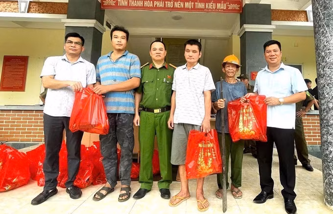 Người dân nhận những phần quà từ lực lượng công an sau khi giao nộp vũ khí. Ảnh: TTXVN phát