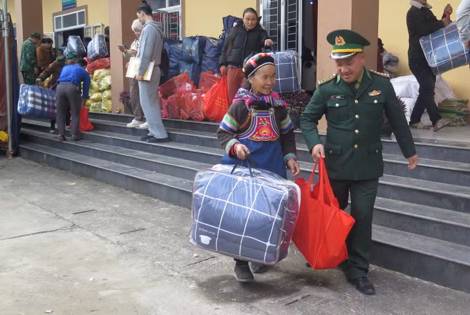 Người dân phấn khởi khi được cán bộ Biên phòng hỗ trợ nhận quà Tết.