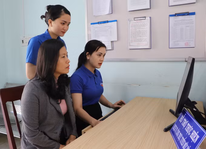 Đoàn thanh niên Tổ công nghệ số cộng đồng phường Chánh Lộ, thành phố Quảng Ngãi hướng dẫn người dân thực hiện các dịch vụ công trực tuyến. Ảnh: Đinh Hương – TTXVN