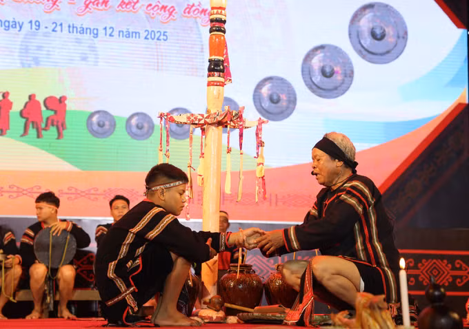 Thầy cúng đeo vòng tay cầu sức khỏe, may mắn cho trẻ em trong lễ Mừng tuổi cho trẻ em của đồng bào người Ê Đê.