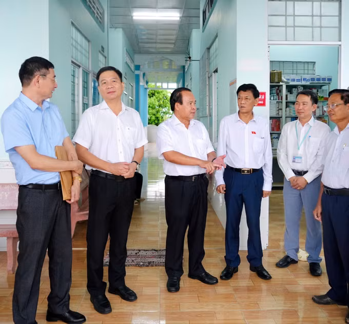 Phó Chủ tịch UBND tỉnh Cà Mau Nguyễn Minh Luân (thứ ba, từ trái sang) và Chủ tịch Hội đồng Dân tộc của Quốc hội Lâm Văn Mẫn (thứ tư, từ trái sang) tại buổi khảo sát thực tế ở Trạm Y tế xã Khánh Lâm. Ảnh: Huỳnh Anh/TTXVN