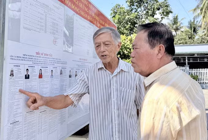Cử tri xã Tri Tôn, An Giang xem danh sách cử tri được niêm yết công khai tại khu vực bỏ phiếu.