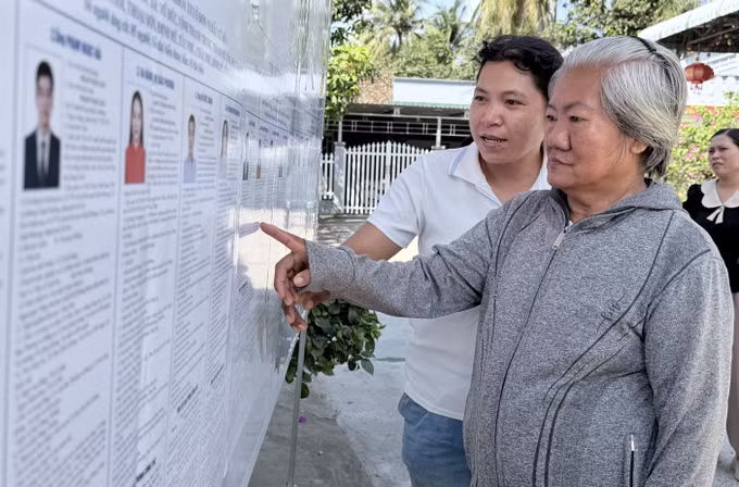 Cử tri xã Tri Tôn, An Giang xem danh sách cử tri được niêm yết công khai tại khu vực bỏ phiếu.