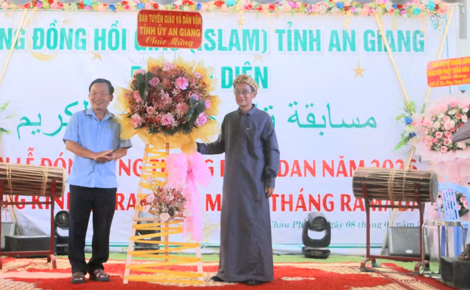 Ông Nguyễn Hữu Thịnh, Phó Trương Ban Tuyên giáo và Dân vận tỉnh An Giang (trái) tặng hoa chúc mừng Ban Đại diện Cộng đồng Hồi giáo Islam.