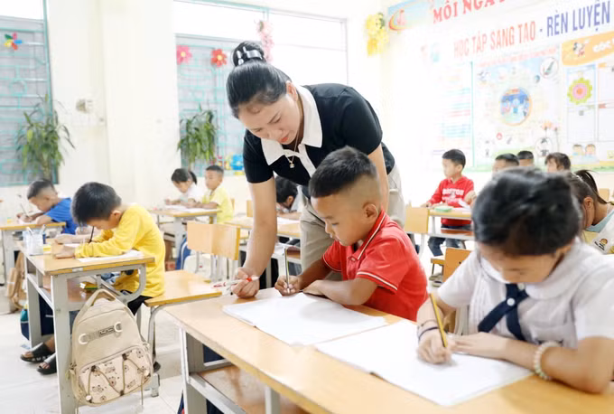 Giáo viên Trường Phổ thông Dân tộc Bán trú Tiểu học và Trung học cơ sở Thu Lũm hướng dẫn học sinh lớp 1 tập viết chữ.