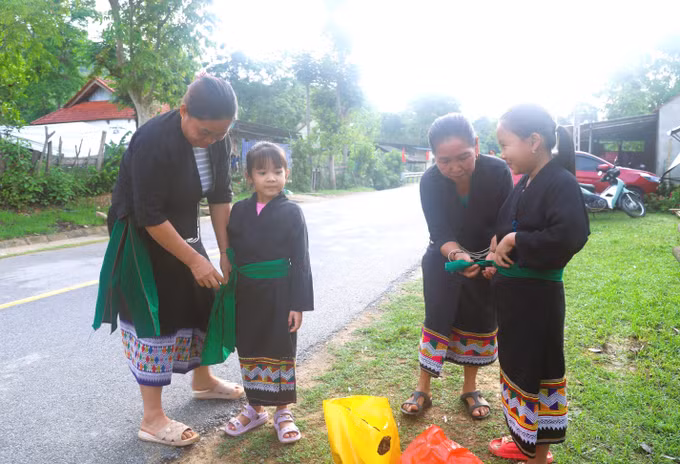 Phụ nữ dân tộc Ơ Đu chỉnh sửa trang phục truyền thống cho con cháu tham gia dự lễ hội đốn tiếng sấm đầu năm của dân tộc Ơ Đu.