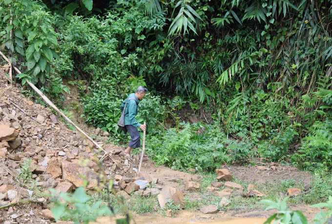 Người dân bản Xốp Kho (xã Nga My, Nghệ An) khó khăn khi tìm cách di chuyển qua điểm sạ lở trên tuyến đường Xốp Kho- Na Ngân. Ảnh: Xuân Tiến/TTXVN