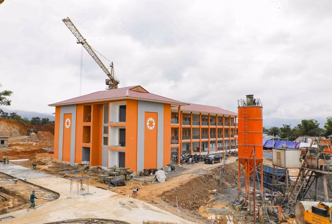 Khối nhà học kết hợp khu nội trú nổi bật giữa công trường đang được hoàn thiện những hạng mục cuối.