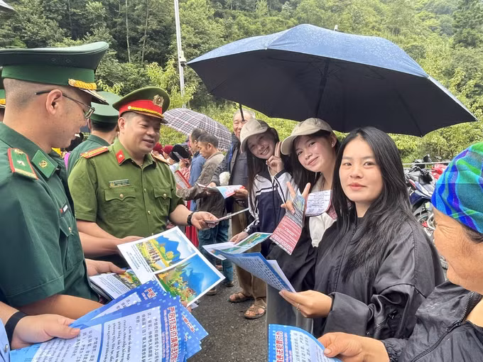 Cư dân biên giới nhận tờ rơi tuyên truyền pháp luật tại lối mở Phó Bảng - Đổng Cán.