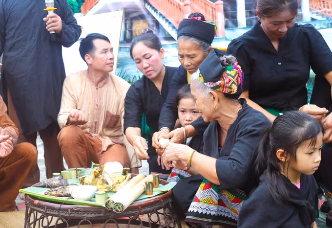 Sau nghi thức cúng, quả trứng gà đã luộc chín trên mâm cúng sẽ được chia cho các em nhỏ có mặt để dự lễ đặt tên, nhập họ và buộc chỉ cổ tay.