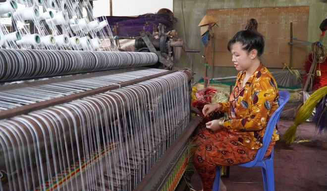 Đa số hộ làm nghề dệt chiếu ở Định Yên đều sử dụng máy dệt, giúp nâng cao sản lượng và chất lượng chiếu. (Ảnh: Nhựt An/TTXVN) a111.jpg