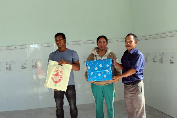 Chính quyền xã Hơ Moong tặng quà cho vợ chồng anh A Táo ở thôn Đăk Wớt Yôp trong ngày nhận bàn giao nhà mới. Ảnh: Cao Nguyên-TTXVN potal-huyen-sa-thay-kon-tum-phan-dau-hoan-thanh-xoa-nha-tam-nha-dot-nat-trong-nam-2025-7824555.jpg