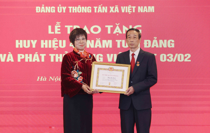 Đồng chí Vũ Việt Trang, Uỷ viên Ban Chấp hành Đảng bộ Khối các cơ quan Trung ương, Bí thư Đảng uỷ, Tổng Giám đốc Thông tấn xã Việt Nam trao Huy hiệu 40 năm tuổi Đảng cho đồng chí Thân Văn Hạnh. Ảnh: Phương Hoa - TTXVN potal-dang-uy-ttxvn-to-chuc-trao-tang-huy-hieu-dang-va-phat-the-dang-vien-dot-32-7836721.jpg