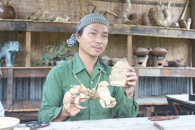 Anh Lê Ngọc Dư cùng các đốt tre, gốc tre để tạo dáng cho một con ốc mượn hồn. Ảnh: Thanh Tân - TTXVN potal-thoi-hon-nghe-thuat-vao-nhung-dot-tre-7832571.jpg