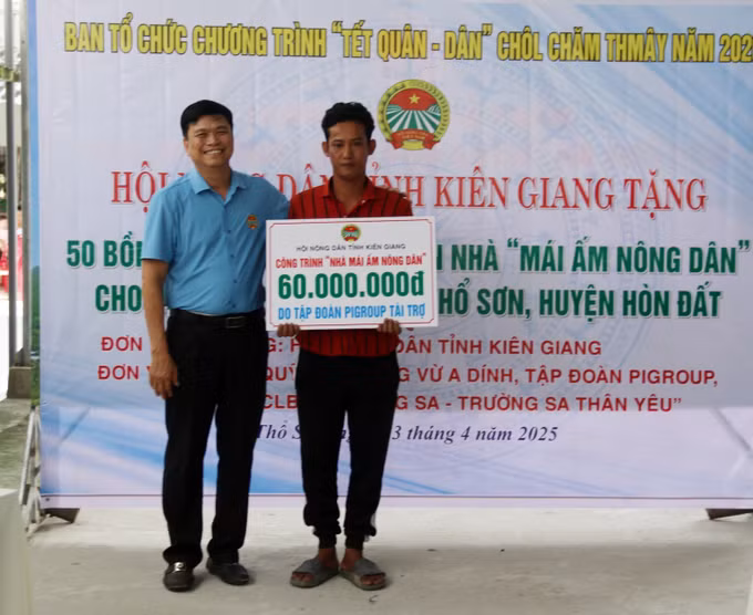 Chủ tịch Hội Nông dân tỉnh Kiên Giang Đỗ Trần Thịnh trao bảng biểu trưng tặng nhà mái ấm nông dân cho hội viên nông dân Khmer Danh Nõ. Ảnh: Lê Sen – TTXVN