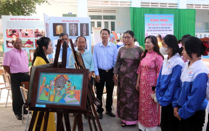 Các đại biểu và học sinh tham quan triển lãm ảnh. Ảnh: Hồng Hiếu- TTXVN potal-binh-thuan-trien-lam-tranh-hoc-sinh-voi-di-san-van-hoa-dia-phuong-va-chu-quyen-bien-dao-viet-nam-7970796.jpg