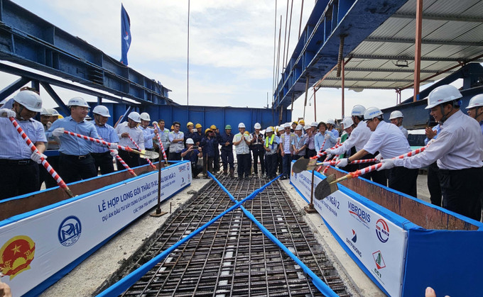 Các đại biểu thực hiện nghi thức hợp long cầu Đại Ngãi 2. Ảnh: Trung Hiếu - TTXVN potal-hop-long-cau-dai-ngai-2-bac-qua-song-hau-7791114.jpg
