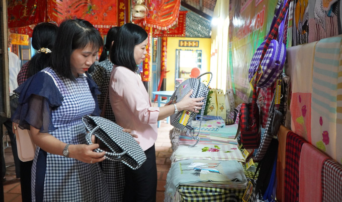 Khách hàng chọn mua những sản phẩm của Làng nghề dệt choàng xã Long Khánh A, huyện Hồng Ngự. Ảnh: Nhựt An - TTXVN potal-dong-thap-tang-cuong-bao-ton-va-phat-trien-cac-lang-nghe-7917095.jpg