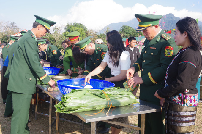 Các cán bộ, chiến sỹ biên phòng và người dân gói bánh chưng. Ảnh: Thanh Thuỷ-TTXVN potal-xuan-bien-phong-am-long-dan-ban-tai-quang-tri-7796193.jpg