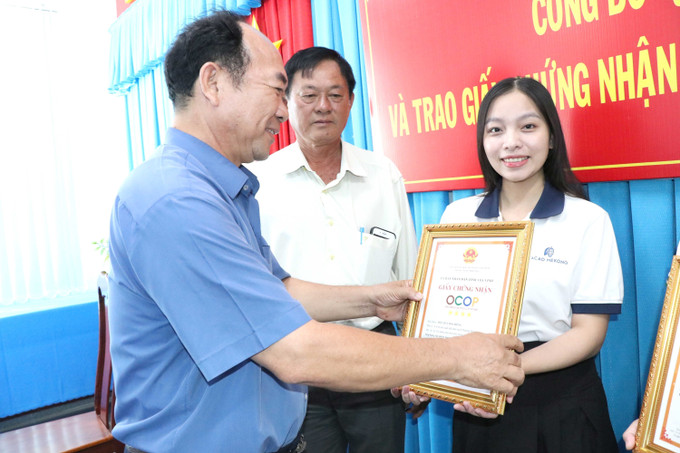 Ông Huỳnh Kim Nhân, Phó Giám đốc Sở Nông nghiệp và Phát triển nông thôn tỉnh Trà Vinh trao Giấy chứng nhận OCOP 4 sao cho sản phẩm Bột cacao nguyên chất của Công ty TNHH Cacao Mekong (xã Song Lộc, huyện Châu Thành). Ảnh: Thanh Hòa - TTXVN potal-tra-vinh-cong-bo-va-trao-giay-chung-nhan-san-pham-ocop-4-sao-7878000.jpg