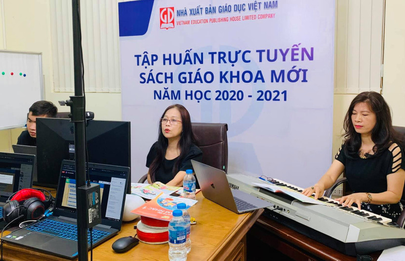TS. Đỗ Thị Minh Chính (người ở giữa), Tổng chủ biên SGK Âm nhạc 1 thuộc bộ sách Kết nối tri thức với cuộc sống hướng dẫn giáo viên sử dụng SGK mới. Ảnh: PM
