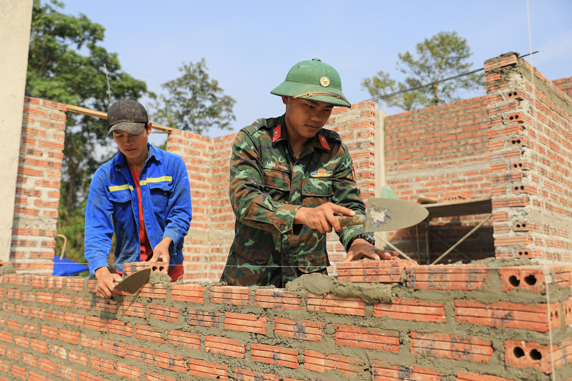 Cán bộ, chiến sĩ thuộc Trung đoàn 741 (Bộ Chỉ huy Quân sự tỉnh Điện Biên) xây nhà cho các hộ dân ở bản Mường Pồn 2. Ảnh: Phan Quân/TTXVN Cán bộ, chiến sĩ thuộc Trung đoàn 741 (Bộ Chỉ huy Quân sự tỉnh Điện Biên) xây nhà cho các hộ dân ở bản Mường Pồn 2. Ảnh: Phan Quân/TTXVN