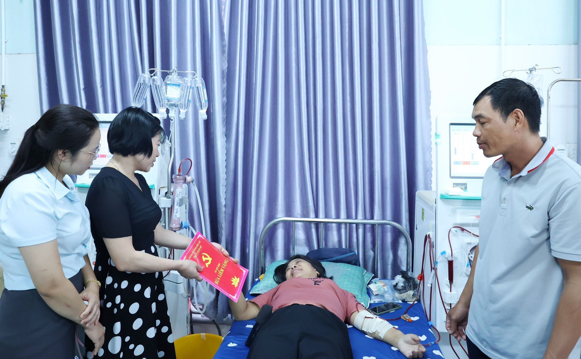 Lãnh đạo Ban Tuyên giáo và Dân vận Thị ủy Buôn Hồ, tỉnh Đắk Lắk trao “Sổ tiết kiệm Búa liềm vàng” hỗ trợ đảng viên bị bệnh hiểm nghèo. Ảnh: Hoài Thu/TTXVN dak-lak4-1605.jpg