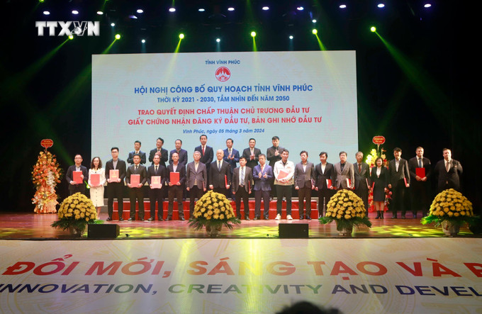 Các nhà đầu tư nhận giấy chứng nhận đăng kí đầu tư và biên bản ghi nhớ đầu tư tại hội nghị. Ảnh: Hoàng Hùng – TTXVN vna_potal_pho_thu_tuong_chinh_phu_tran_hong_ha_du_hoi_nghi_cong_bo_quy_hoach_tinh_vinh_phuc_7255445.jpg