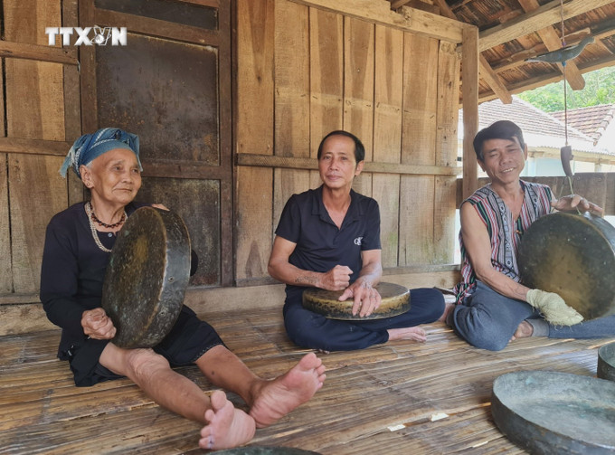 Nghệ nhân ưu tú Phạm văn Rôm (phải) đánh chiêng cùng người dân Hrê. Ảnh: TTXVN phát vna_potal_quang_ngai_nhung_nguoi_gop_phan_bao_ton_van_hoa_dong_bao_hre_7364259.jpg