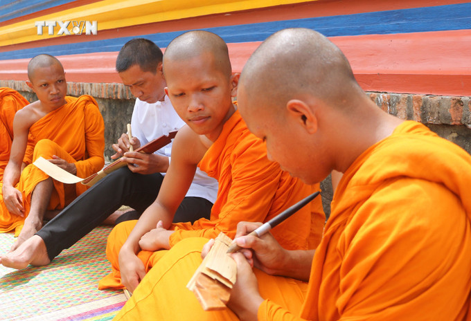 Người viết chữ trên lá buông, phải dùng một loại bút đặc biệt được làm bằng gỗ, vừa tay cầm, một đầu có mũi nhọn bằng kim loại gọi là Đek-cha để “khắc” chữ lên lá buông. Mỗi lá kinh sẽ viết được từ 4-5 dòng, mỗi dòng từ 15 đến 20 chữ. Ảnh: Công Mạo-TTXVN vna_potal_kinh_la_buong_“bau_vat”_cua_dong_bao_khmer_an_giang_7715255.jpg