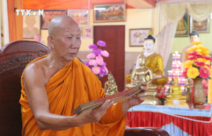 Hòa thượng Chau Sơn Hy, Sư cả chùa Sà Lôn ở xã Lương Phi, huyện Tri Tôn (An Giang) giới thiệu về những bộ kinh lá buông đang được lưu giữ tại chùa. Ảnh: Công Mạo-TTXVN vna_potal_kinh_la_buong_“bau_vat”_cua_dong_bao_khmer_an_giang_7715256.jpg
