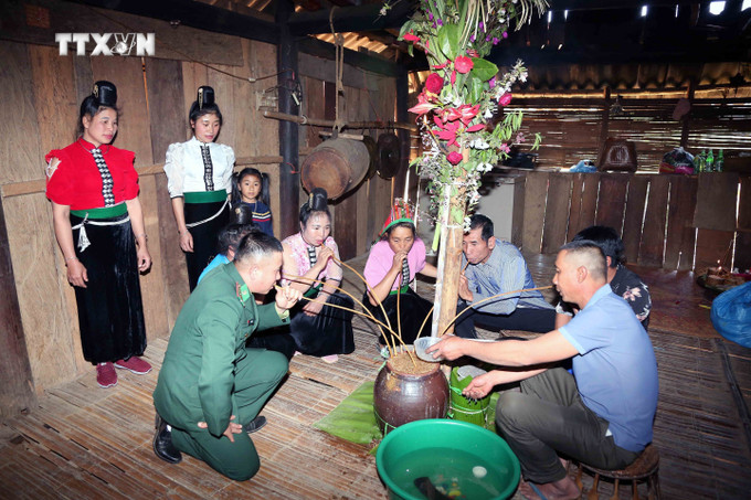 Chủ nhà mời khách mời uống rượu cần sau khi thực hiện xong nghi lễ. Ảnh: Quang Quyết - TTXVN vna_potal_van_hoa_soi_duong_le_sa_tip_-_net_van_hoa_doc_dao_cua_dan_toc_xinh_mun_son_la_7271212.jpg