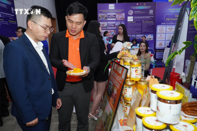Đại diện Công ty TNHH CamlamOnline giới thiệu sản phẩm đặc trưng của doanh nghiệp xoài sấy đến đối tác tham dự chương trình xúc tiến thương mại. Ảnh: Phan Sáu - TTXVN vna_potal_day_manh_xuc_tien_thuong_mai_ket_noi_giao_thuong_nam_trung_bo_-_tay_nguyen__7393302.jpg