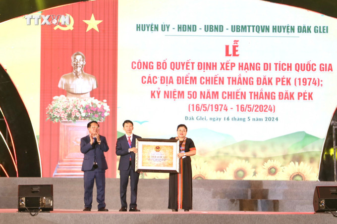 Chủ tịch UBND tỉnh Kon Tum Lê Ngọc Tuấn (ngoài cùng, bên trái) trao Quyết định của Bộ trưởng Bộ Văn hóa, Thể thao và Du lịch xếp hạng Di tích Quốc gia Chiến thắng Đăk Pék cho lãnh đạo huyện Đăk Glei. Ảnh: Khoa Chương - TTXVN vna_potal_ban_hung_ca_chien_thang_dak_pek_7380106.jpg