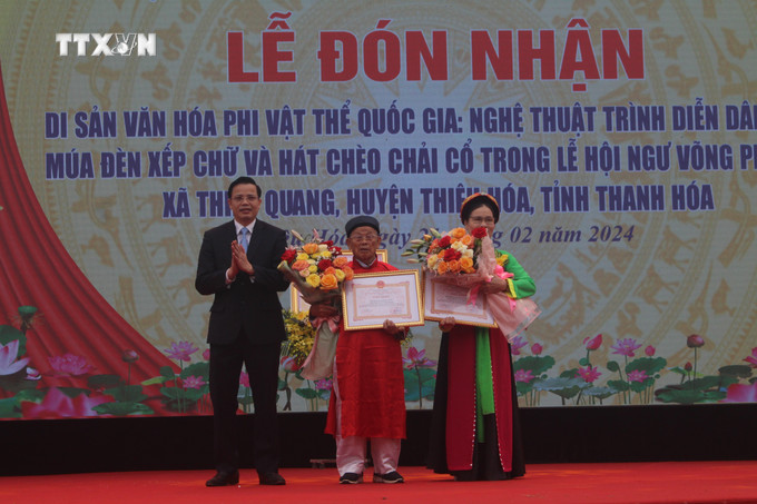 Trao Bằng khen của Chủ tịch UBND huyện Thiệu Hóa cho Nghệ nhân ưu tú Đàm Văn Sừ và Nghệ nhân ưu tú Nguyễn Thị Thủy. Ảnh: Hoa Mai - TTXVN vna_potal_trinh_dien_dan_gian_mua_den_chay_chu_va_hat_cheo_chai_co_duoc_cong_nhan_di_san_van_hoa_phi_vat_the_quoc_gia_7235094.jpg