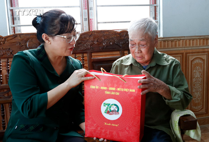 Đoàn công tác thăm hỏi, tặng quà Ông La Văn Kim, sinh năm 1933, thôn Giằng, xã Liêm Phú. Ảnh: Quốc Khánh - TTXVN vna_potal_70_nam_chien_thang_dien_bien_phu_lao_cai_tham_tang_qua_tri_an_dan_cong_hoa_tuyen_chien_si_dien_bien_7337320.jpg