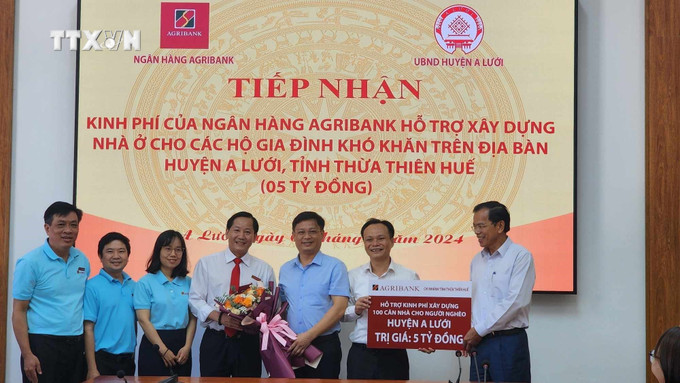 Lãnh đạo tỉnh tặng hoa cho đại diện Agribank chi nhánh tỉnh Thừa Thiên - Huế. Ảnh: TTXVN phát vna_potal_agribank_ho_tro_xay_dung_100_can_nha_cho_ho_ngheo_o_huyen_vung_cao_a_luoi__7465240.jpg