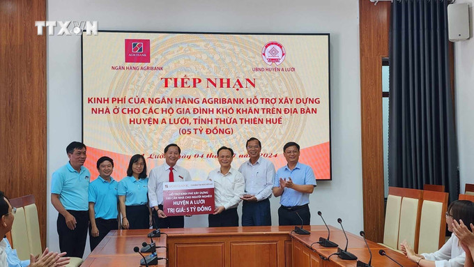 Trao hỗ trợ kinh phí xây dựng 100 căn nhà cho hộ nghèo tại huyện A Lưới. Ảnh: TTXVN phát vna_potal_agribank_ho_tro_xay_dung_100_can_nha_cho_ho_ngheo_o_huyen_vung_cao_a_luoi__7465246.jpg