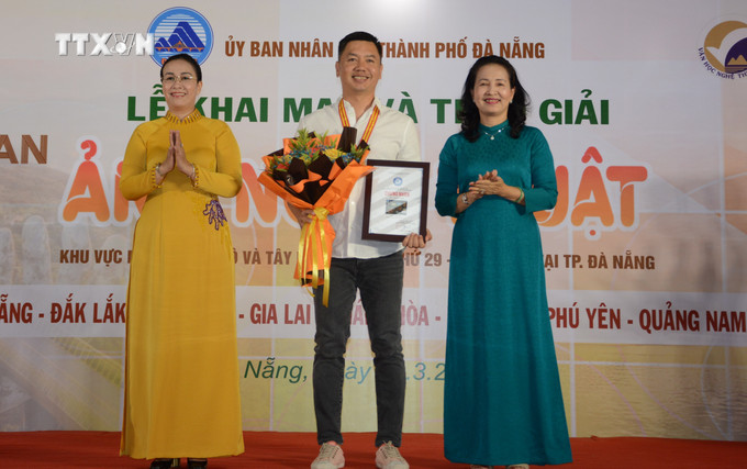 Ban tổ chức trao Huy chương Vàng cho tác giả Nguyễn Ngọc Hòa (Gia Lai) với tác phẩm "Cà phê Việt". Ảnh: Văn Dũng-TTXVN vna_potal_hon_2000_tac_pham_du_thi_lien_hoan_anh_nghe_thuat_khu_vuc_nam_trung_bo_va_tay_nguyen_7296579.jpg